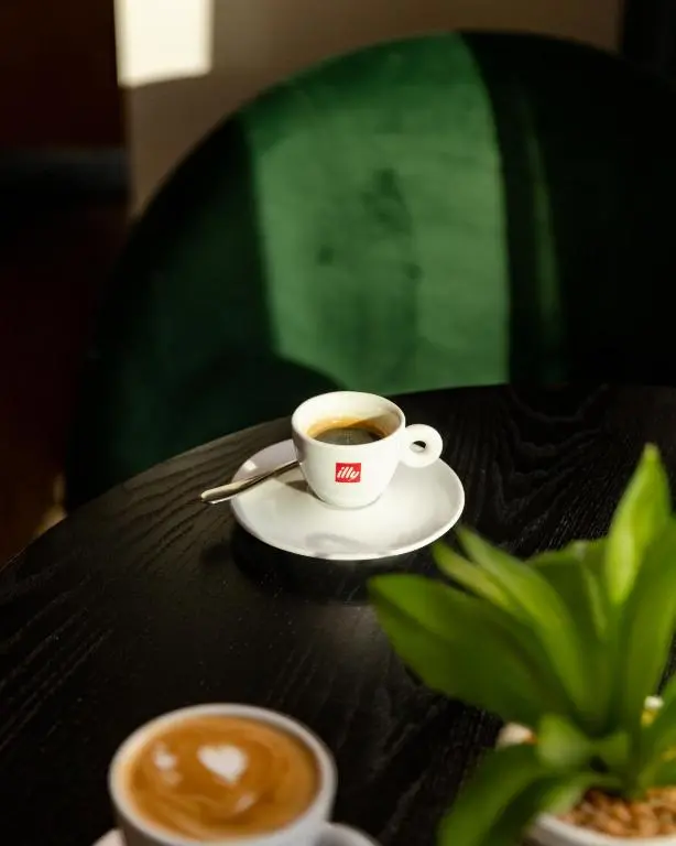 a cup of coffee sitting on top of a table at Leonardo Hotel and Conference Venue Aberdeen Airport in Dyce