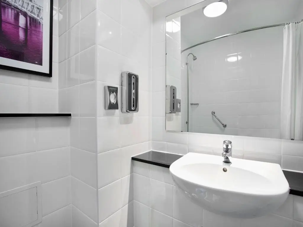 a white bathroom with a sink and a mirror at Leonardo Hotel Inverness in Inverness
