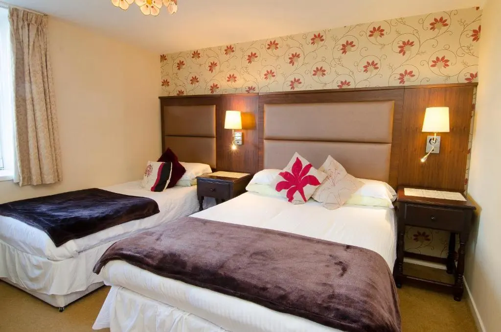 a hotel room with two beds with flowers on them at The Station Hotel in Portsoy