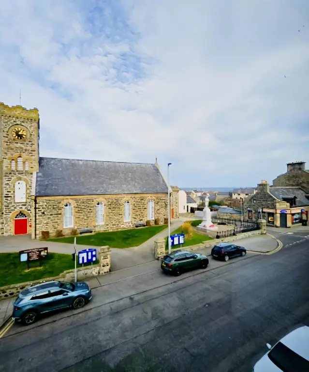 a group of cars parked in front of a church at The Station Hotel in Portsoy