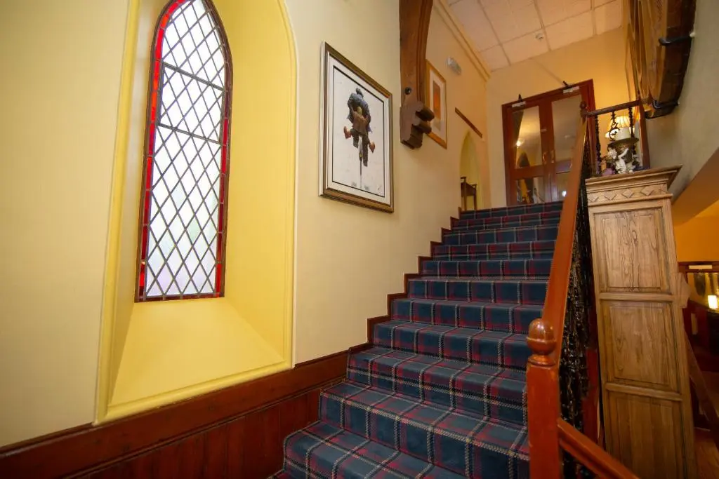 a staircase with a stained glass window and a stair case at The Auld Kirk in Ballater