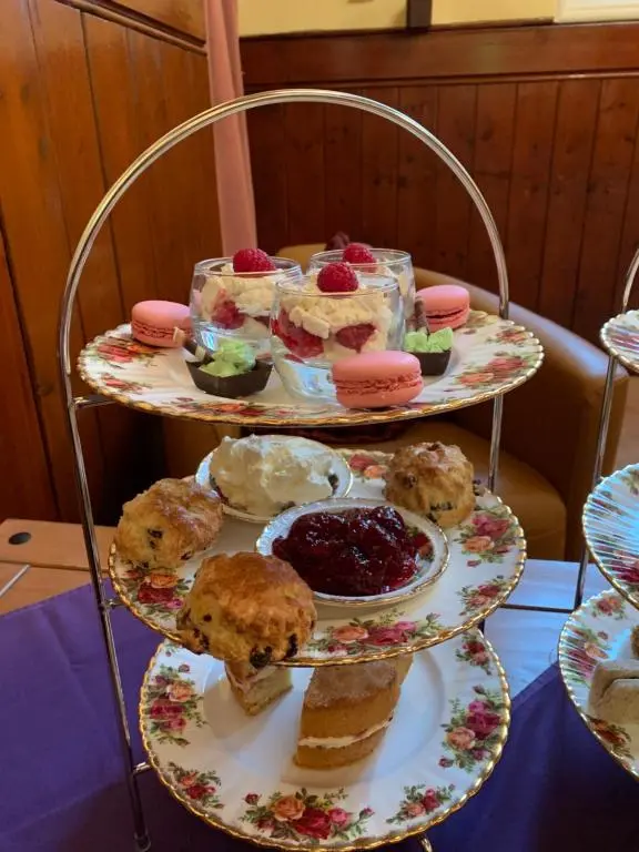 a three tiered tray of food on a table at The Auld Kirk in Ballater
