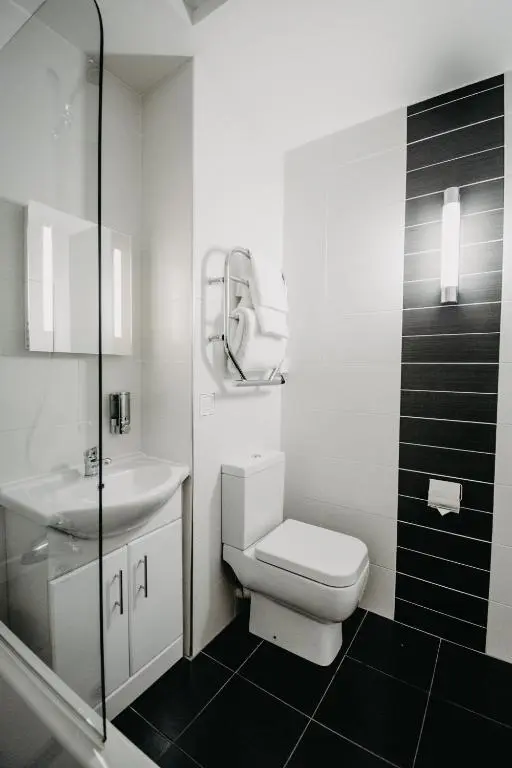 a white bathroom with a toilet and a sink at Banff Springs Hotel in Banff