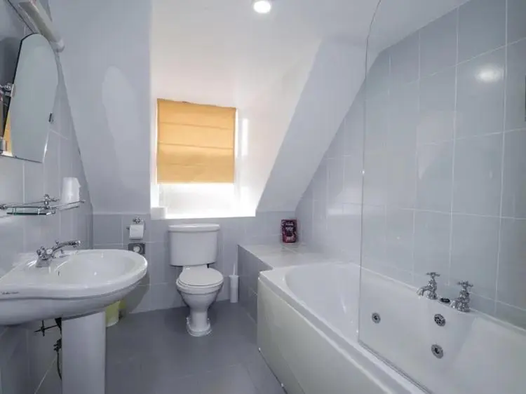 a white bathroom with a sink and a toilet and a tub at McInnes House rooms with breakfast in Kingussie