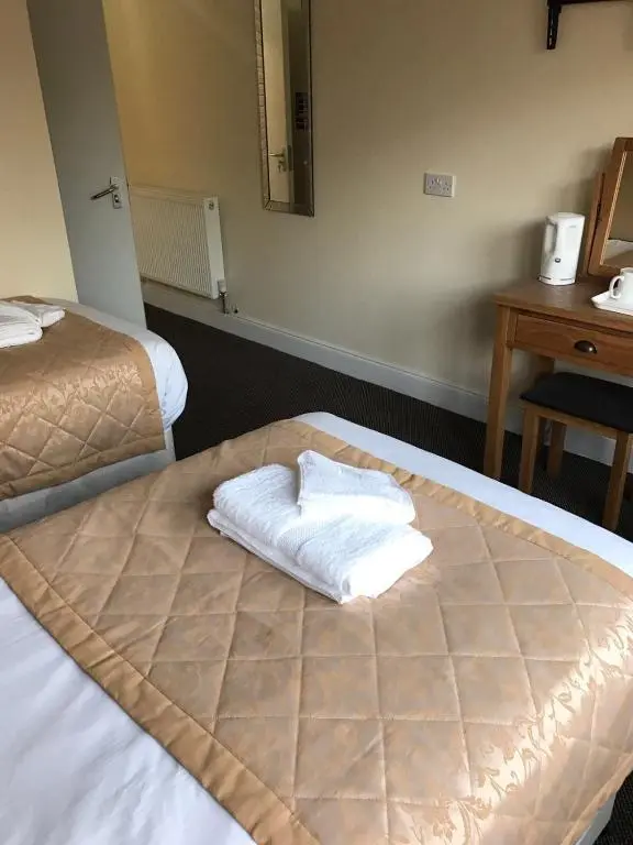 a hotel room with two beds with towels on it at The Waverley Inn in Dingwall
