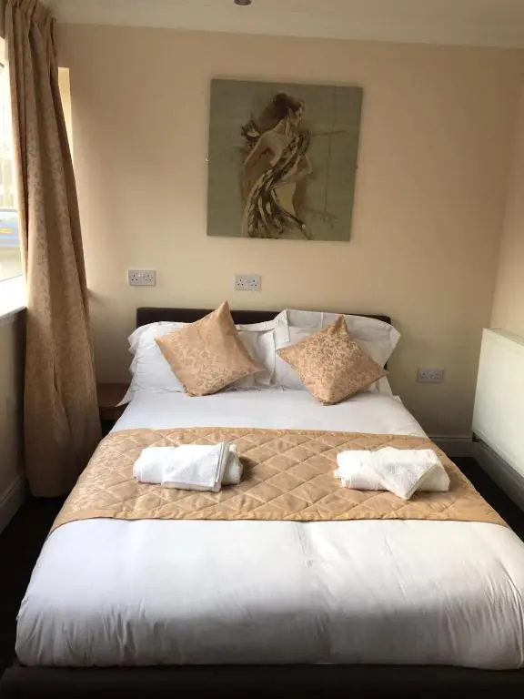 a bedroom with a large bed with two pillows on it at The Waverley Inn in Dingwall