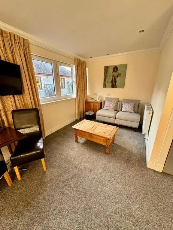 a living room with a couch and a coffee table at The Waverley Inn in Dingwall