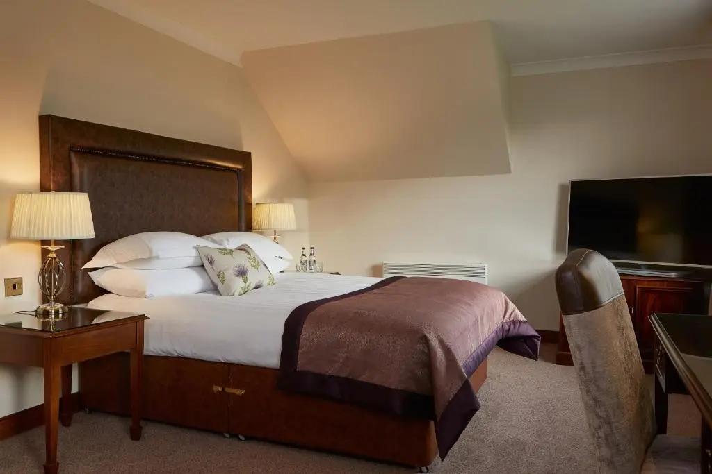 a hotel room with a bed and a television at Macdonald Drumossie Hotel Inverness in Inverness