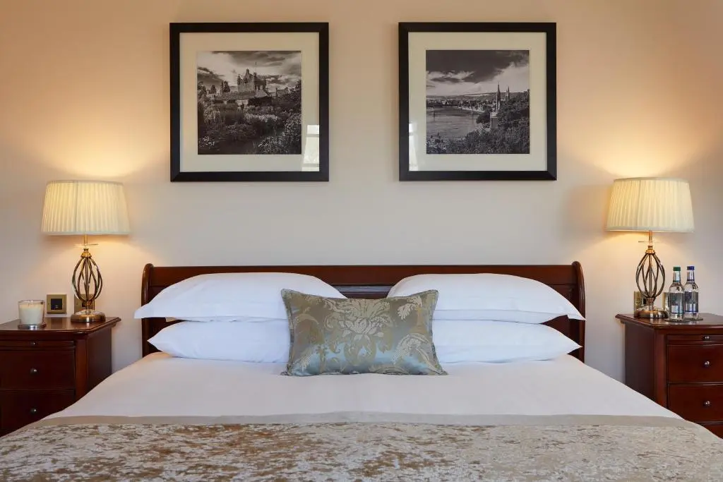 a bedroom with two beds and two pictures on the wall at Macdonald Drumossie Hotel Inverness in Inverness