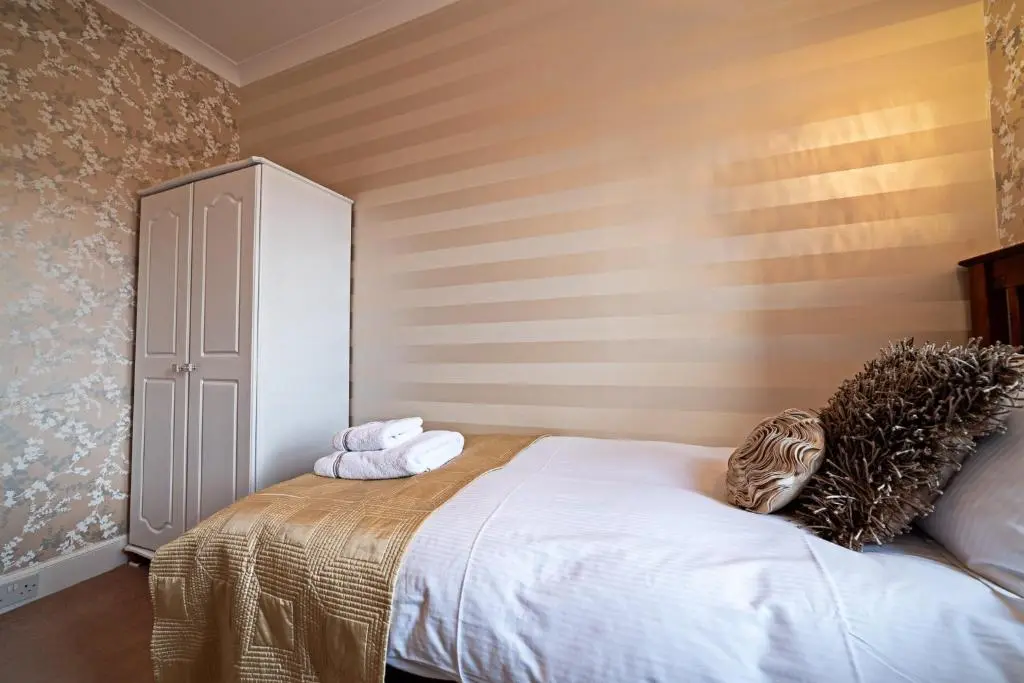 a bedroom with a bed with towels on it at The Rowan Tree Country Hotel in Aviemore