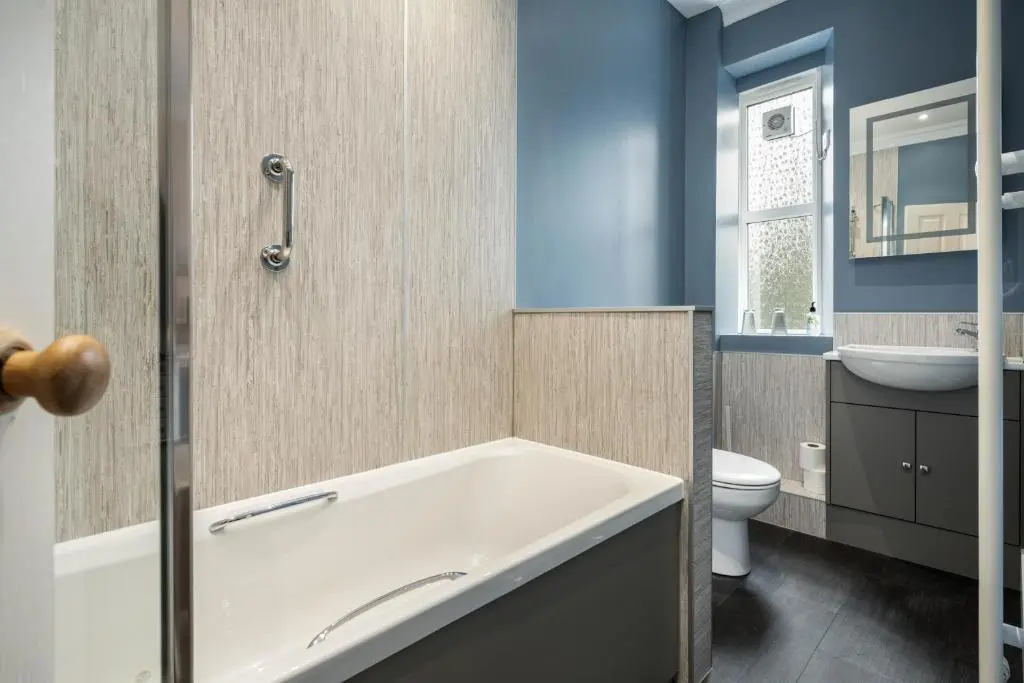 a bathroom with a tub and a toilet and a sink at The Rowan Tree Country Hotel in Aviemore