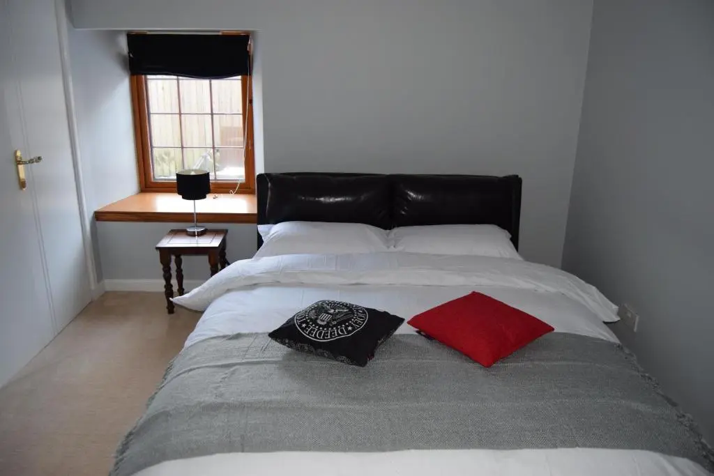a bedroom with a bed with two pillows on it at Amazing 4 Bed Scottish Baronial Style House in Westhill
