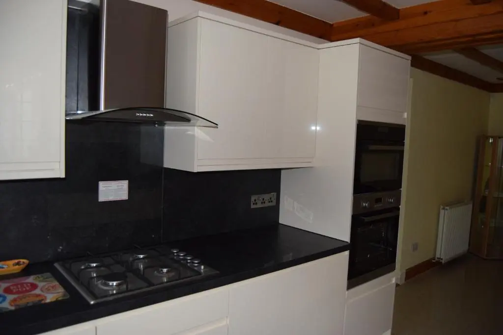 a kitchen with white cabinets and a black counter top at Amazing 4 Bed Scottish Baronial Style House in Westhill