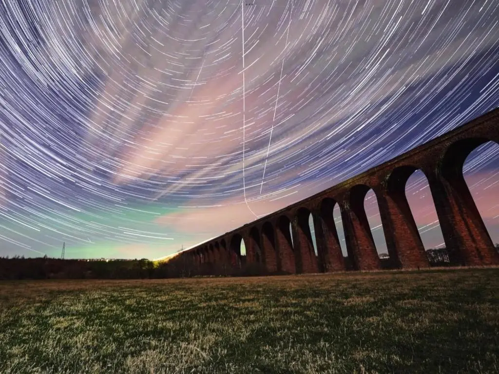 a train bridge with star trails in the sky at Doura Lodge in Inverness