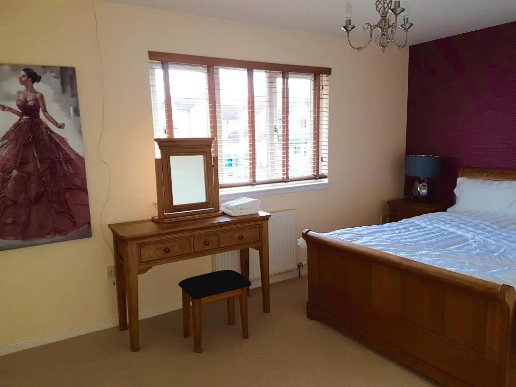 a bedroom with a bed and a mirror on a table at Jane's Villa Free Parking in Inverness