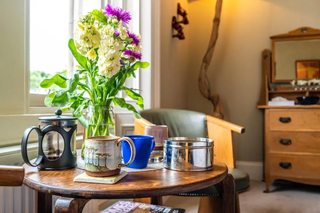 a table with a vase of flowers on it at Washington House in Nairn