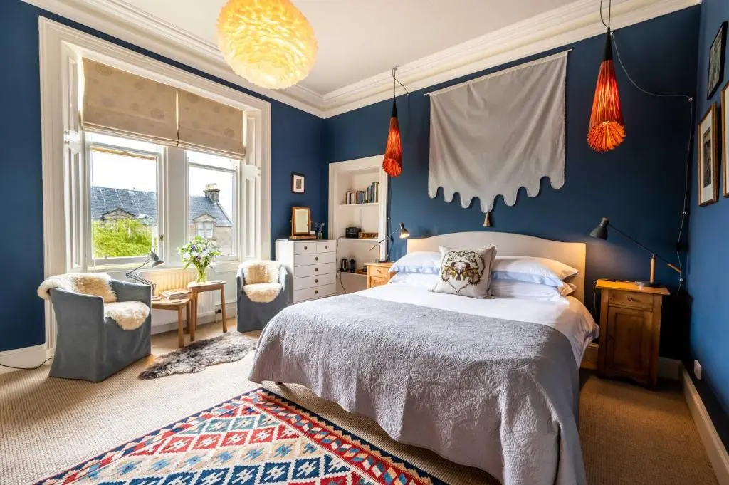 a bedroom with blue walls and a large bed at Washington House in Nairn