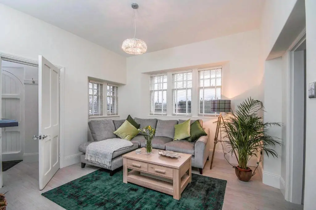 a living room with a couch and a table at Firlands Lodge in Forres