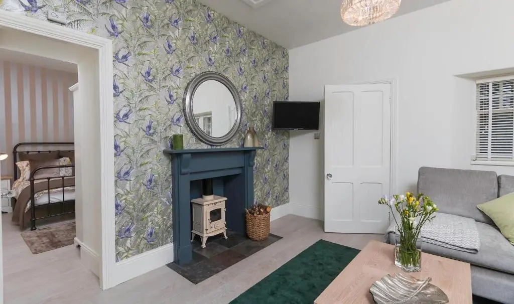 a living room with a blue fireplace and a mirror at Firlands Lodge in Forres