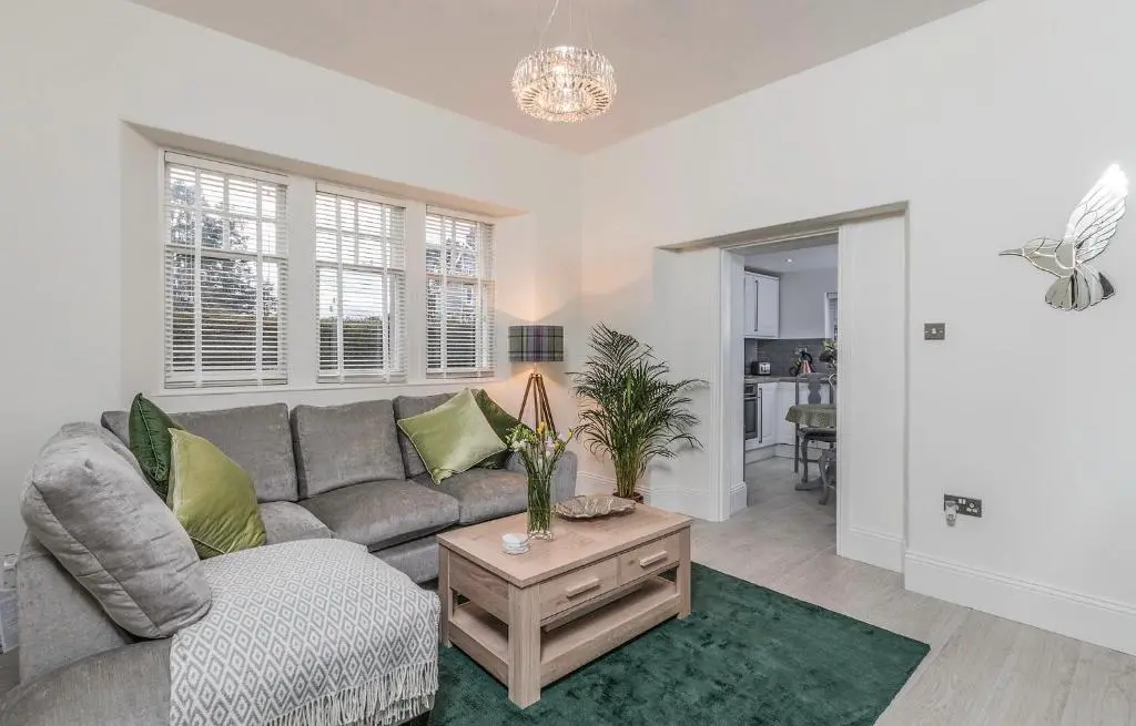 a living room with a couch and a table at Firlands Lodge in Forres