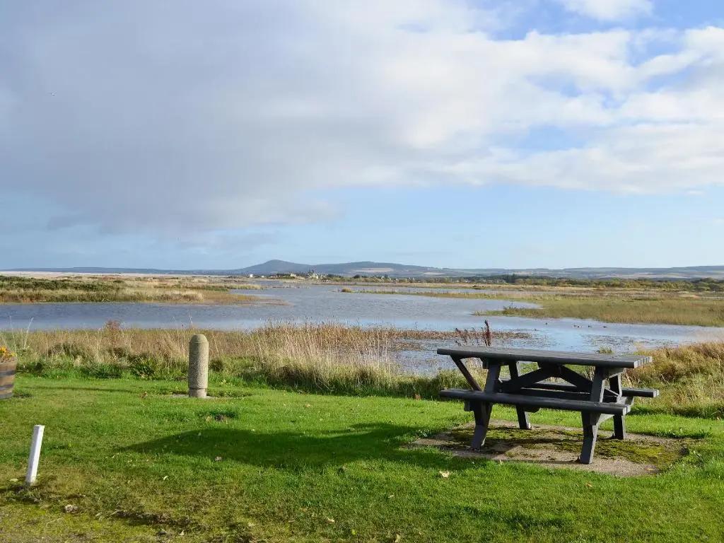 a picnic table sitting next to a body of water at Firth View in Garmouth