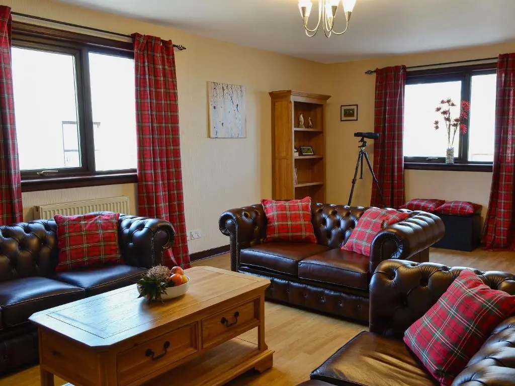 a living room with leather couches and a coffee table at Firth View in Garmouth