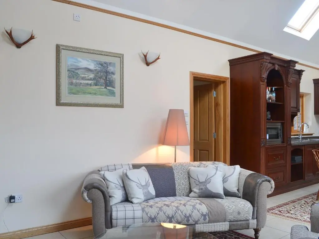 a living room with a couch and a table at Turin Nurin Cottage in Tomatin