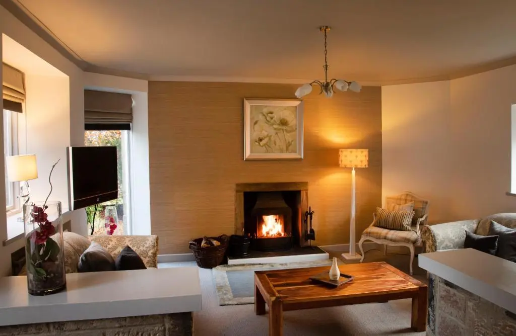 a living room with a fireplace and a couch at Loch Ness Country House Hotel in Inverness