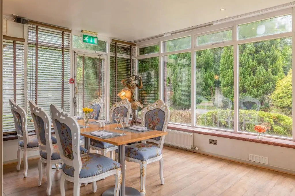 a dining room with a table and chairs and windows at Muthu Newton Hotel (Near Inverness Airport) in Nairn