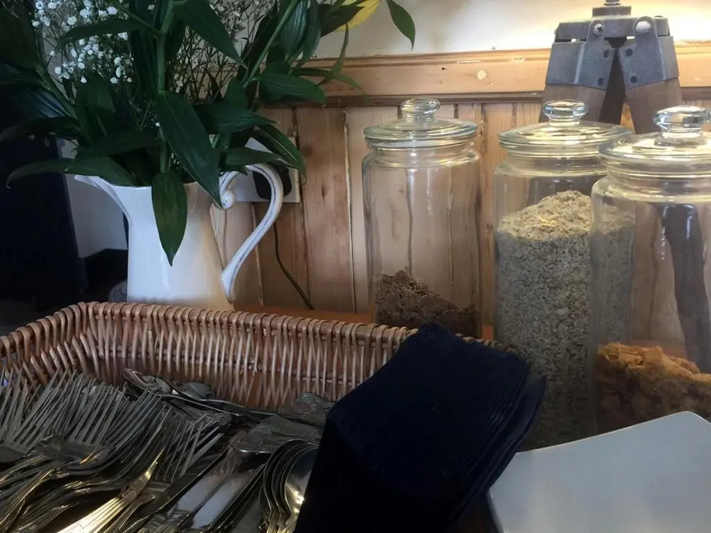 a table with a basket of food and glass jars at Balsporran Bed And Breakfast in Dalwhinnie