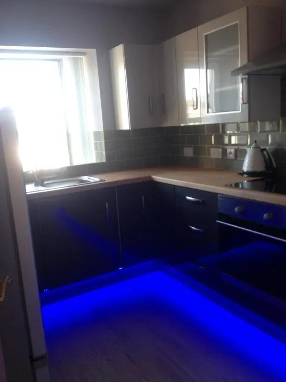 a kitchen with a blue light in the kitchen at Acorn Apartment in Dufftown