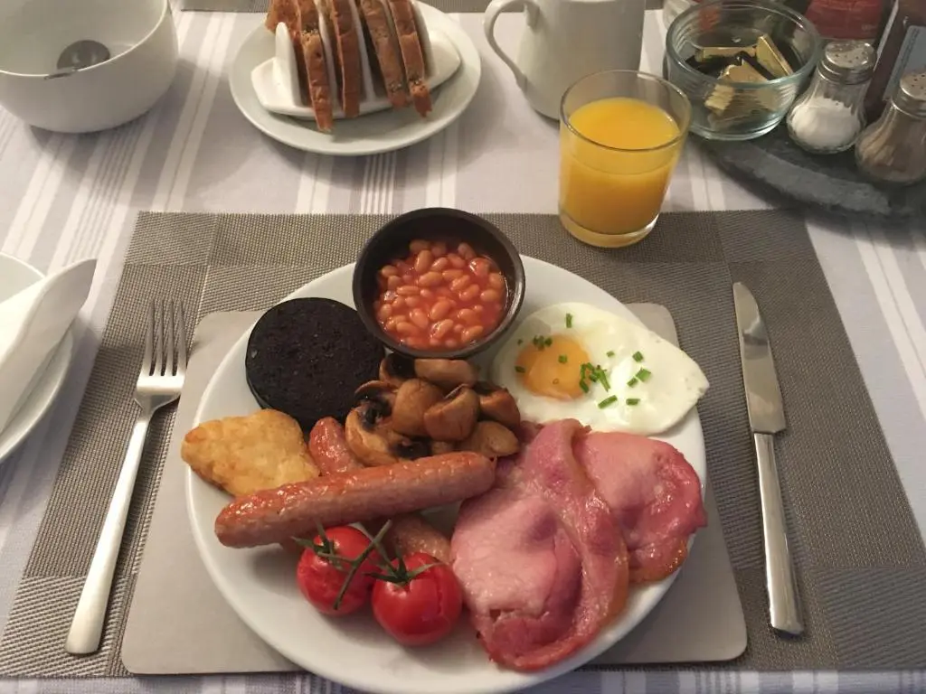 a plate of breakfast food with bacon beans beans and eggs at Urrard B&B in Dingwall