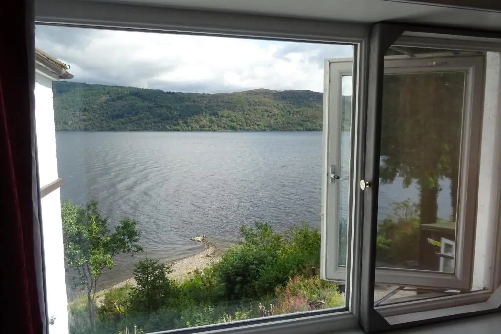 a view of a lake from a window at Loch Ness Lochside Hostel - Over 16s Only in Invermoriston