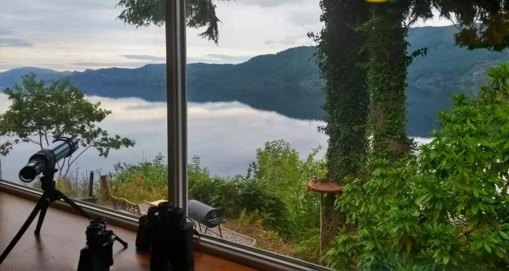 a camera taking a picture of a lake from a window at Loch Ness Lochside Hostel - Over 16s Only in Invermoriston