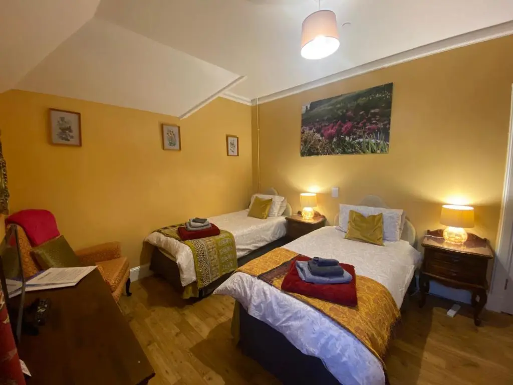 a room with two beds and a desk with two lamps at Forse of Nature in Latheron