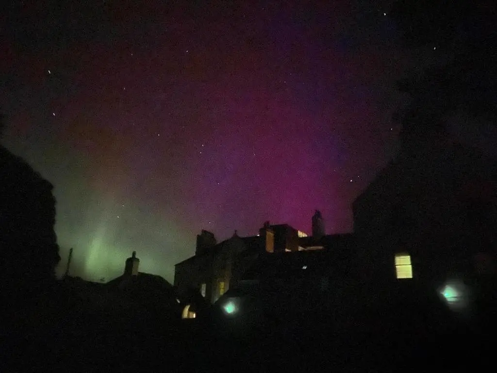an aurora in the sky over a city at night at Forse of Nature in Latheron