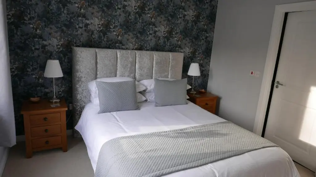 a bedroom with a bed with white sheets and pillows at Hedgefield House Flat 34 in Inverness
