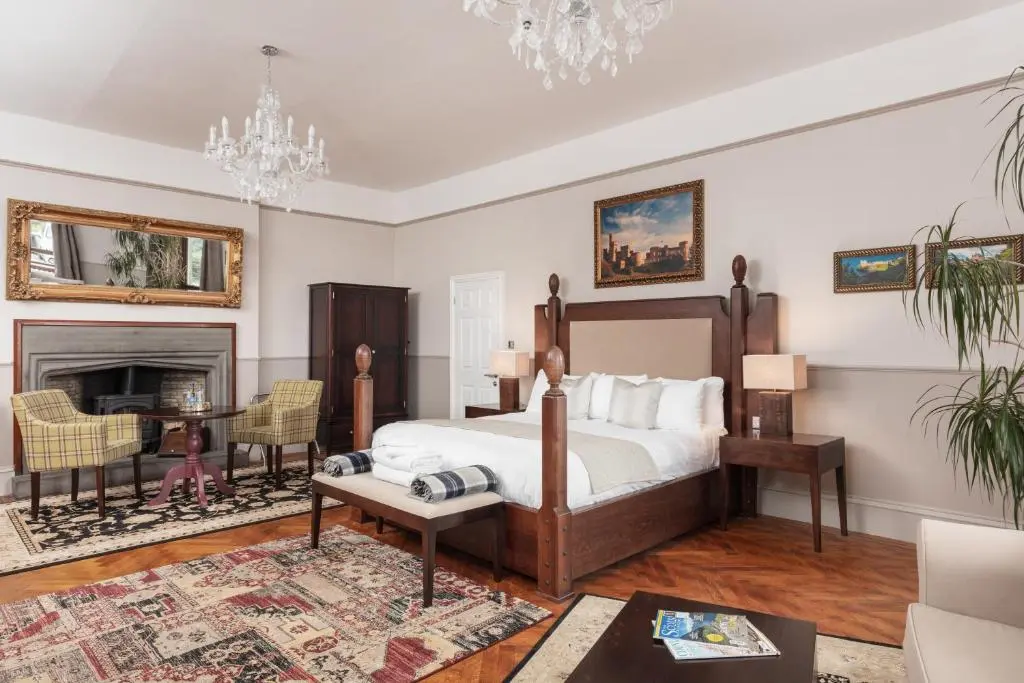 a bedroom with a bed and a fireplace at Tulloch Castle Hotel \u2018A Bespoke Hotel\u2019 in Dingwall