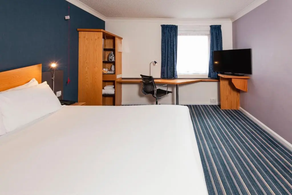 a hotel room with a large bed and a desk at Holiday Inn Express Inverness by IHG in Inverness