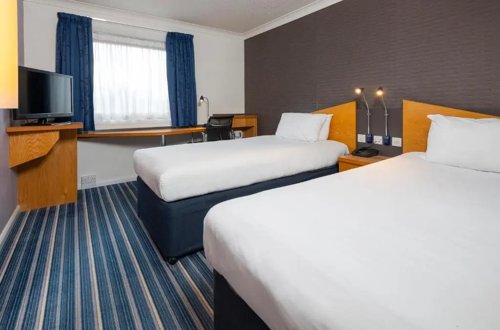 a hotel room with two beds and a television at Holiday Inn Express Inverness by IHG in Inverness