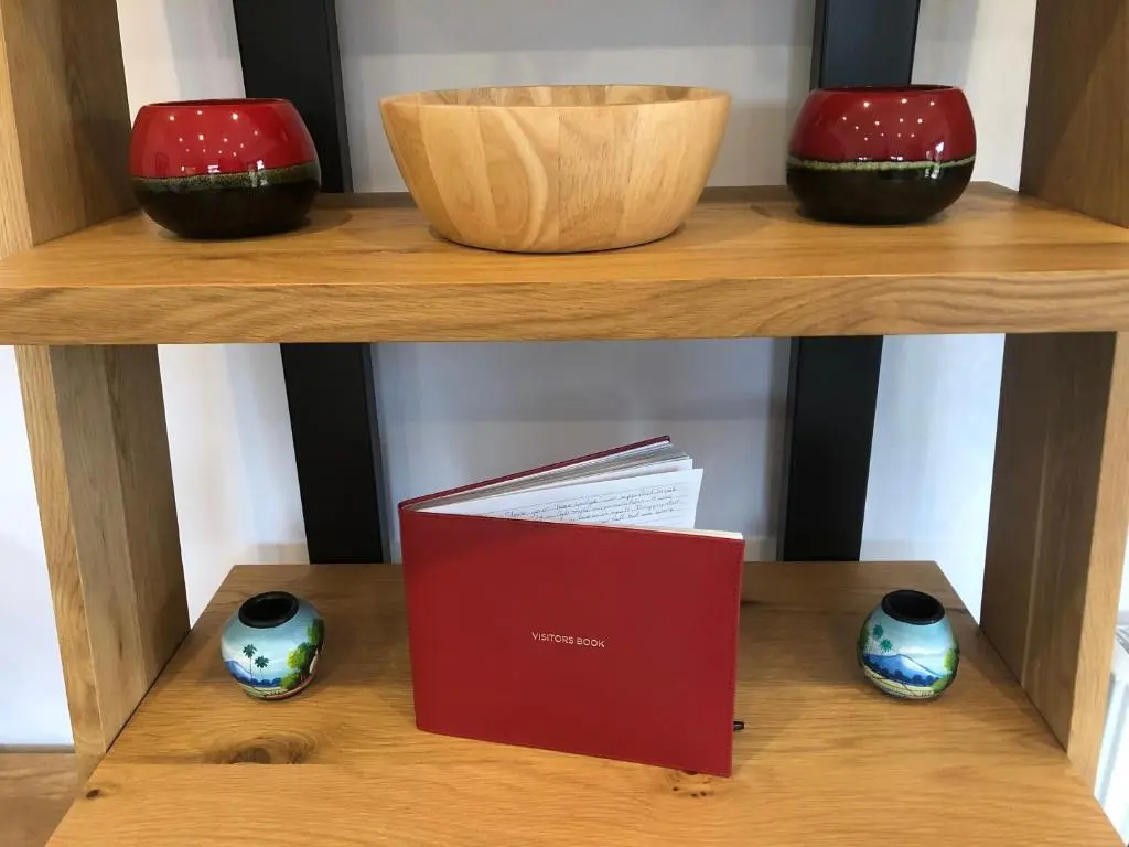 two bowls and a box on a shelf with a book at The Wee Lodge in Inverness