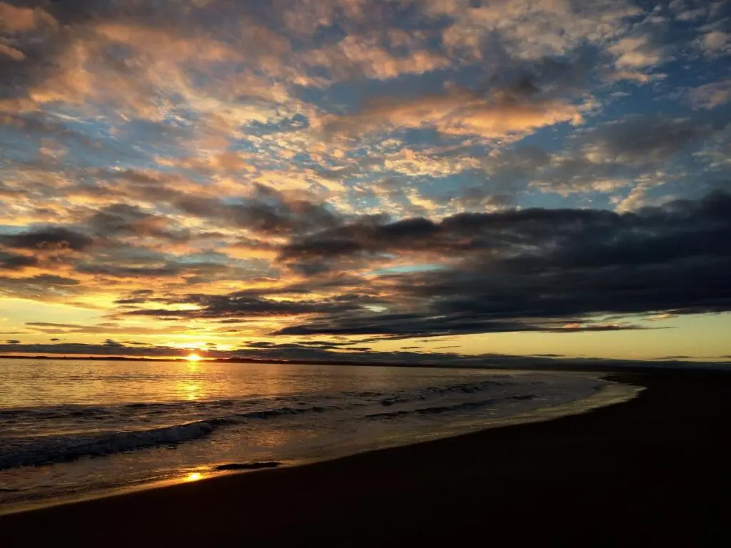 a sunset on a beach with the ocean at Albatross B&B Dornoch in Dornoch