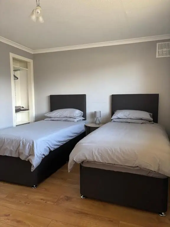 two beds sitting next to each other in a bedroom at Wick Apartment in Wick
