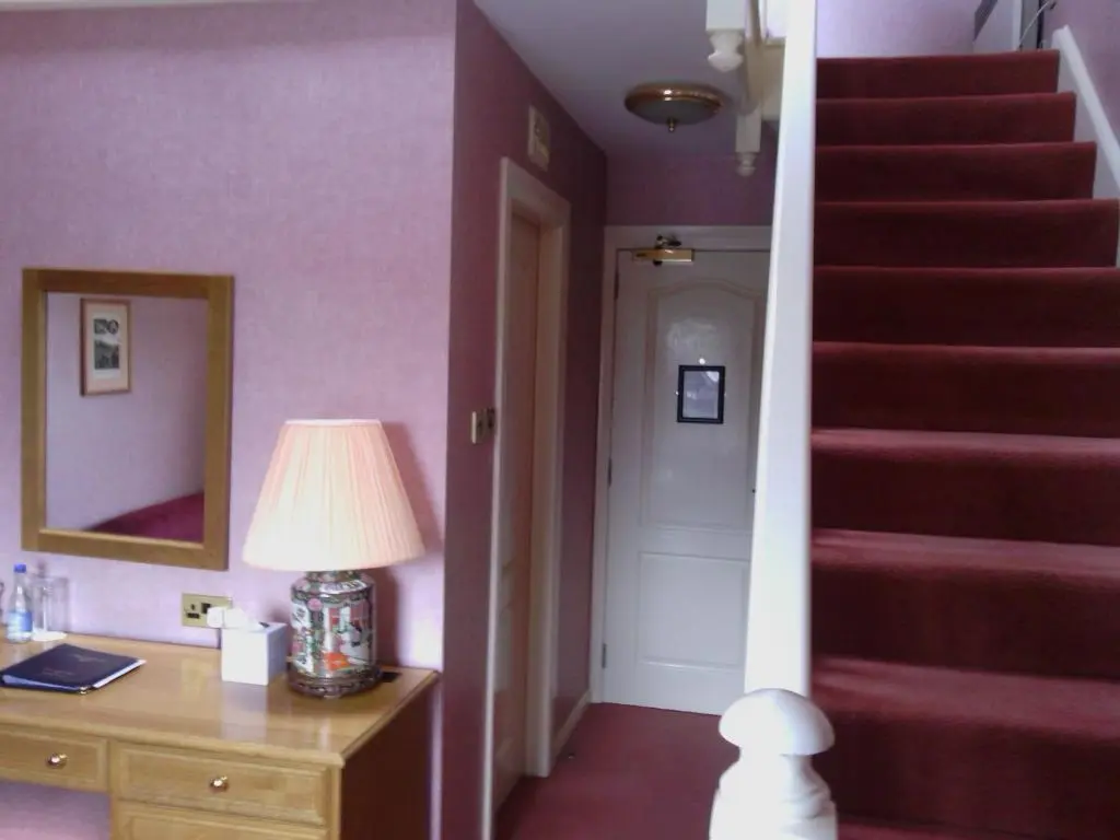 a room with purple walls and a staircase with a lamp at The Craighaar Hotel in Aberdeen