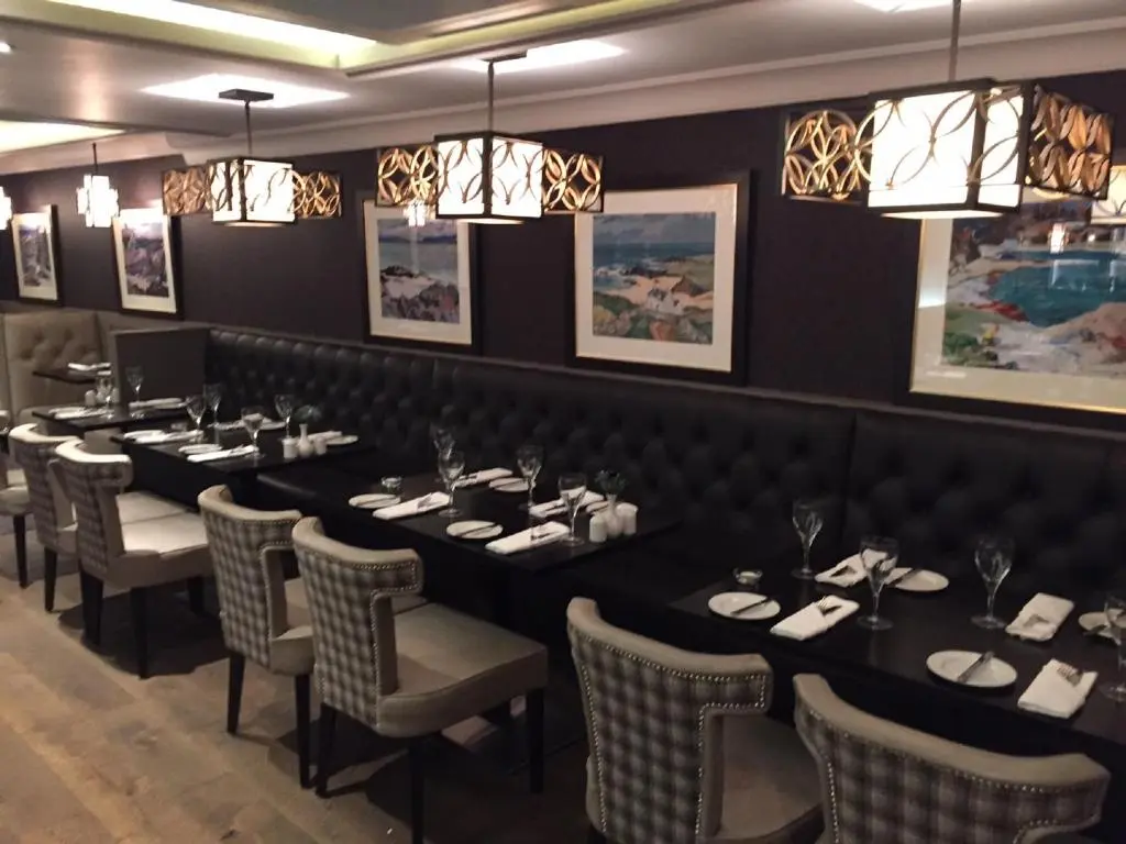 a dining room with long tables and chairs and chandeliers at The Craighaar Hotel in Aberdeen
