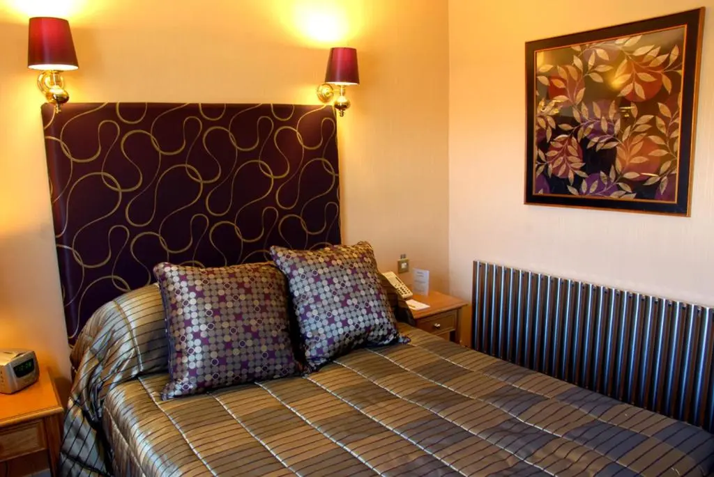 a bedroom with a bed with two pillows on it at The Craighaar Hotel in Aberdeen