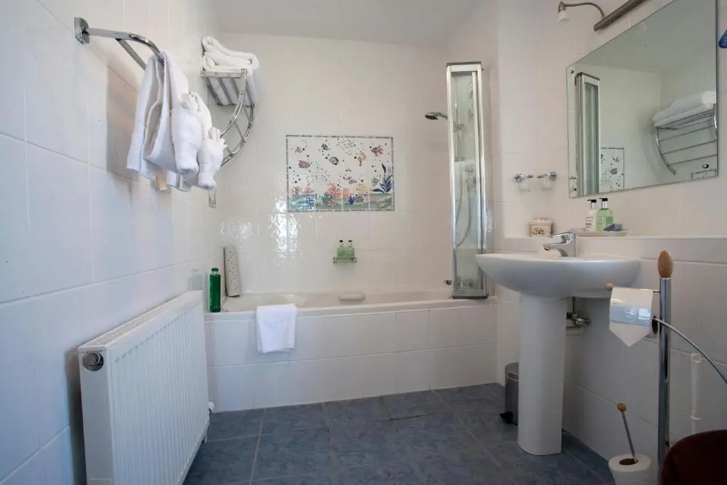 a white bathroom with a sink and a bath tub at Sunny Brae Bed & Breakfast in Nairn
