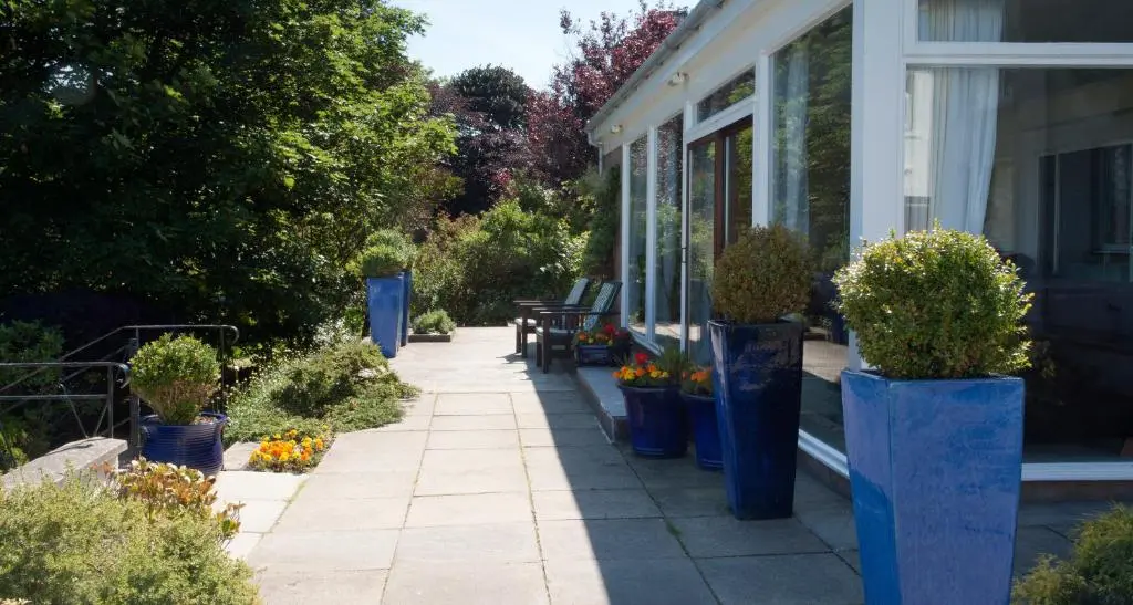 a porch of a house with blue vases of plants at Sunny Brae Bed & Breakfast in Nairn