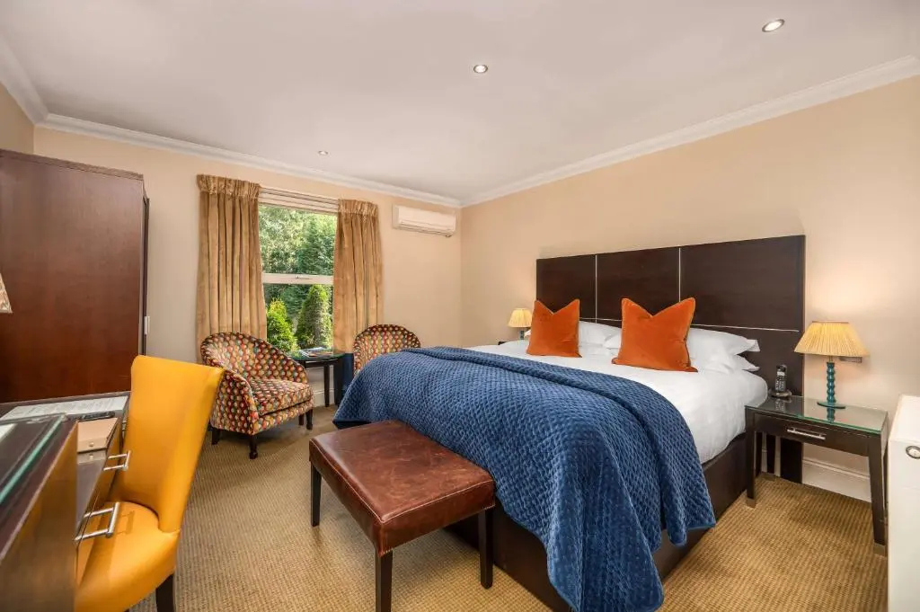 a hotel room with a bed with orange pillows at Rocpool Reserve in Inverness