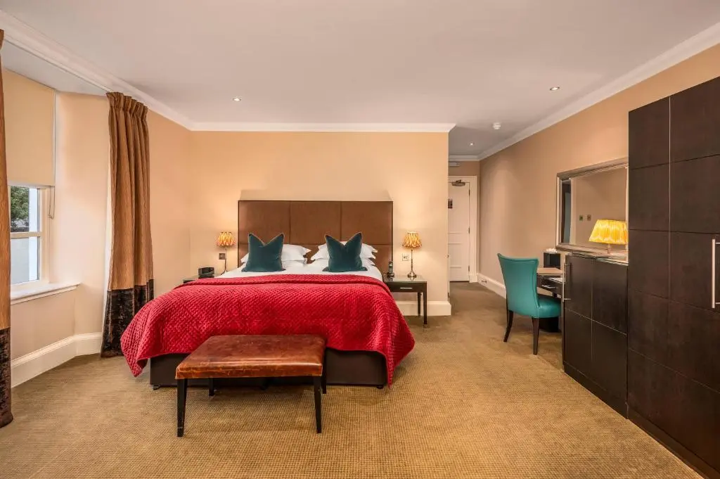 a bedroom with a large bed with a red bedspread at Rocpool Reserve in Inverness